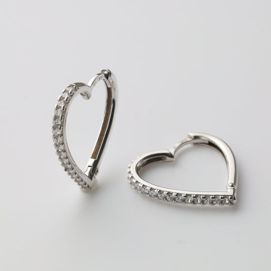 Silver heart-shaped huggie earrings close-up - Kabluchka