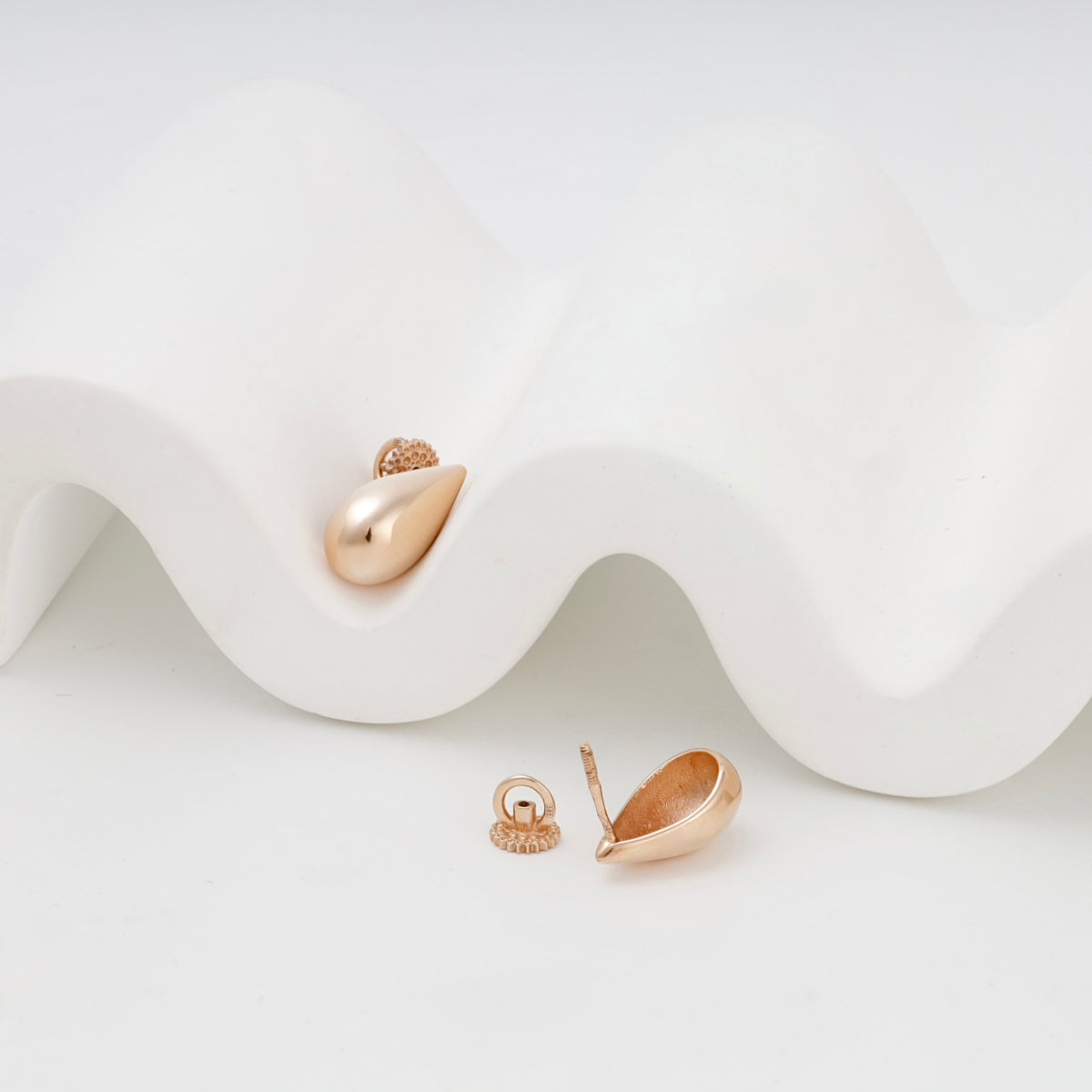 Rose Gold polished teardrop stud earrings, angled front view