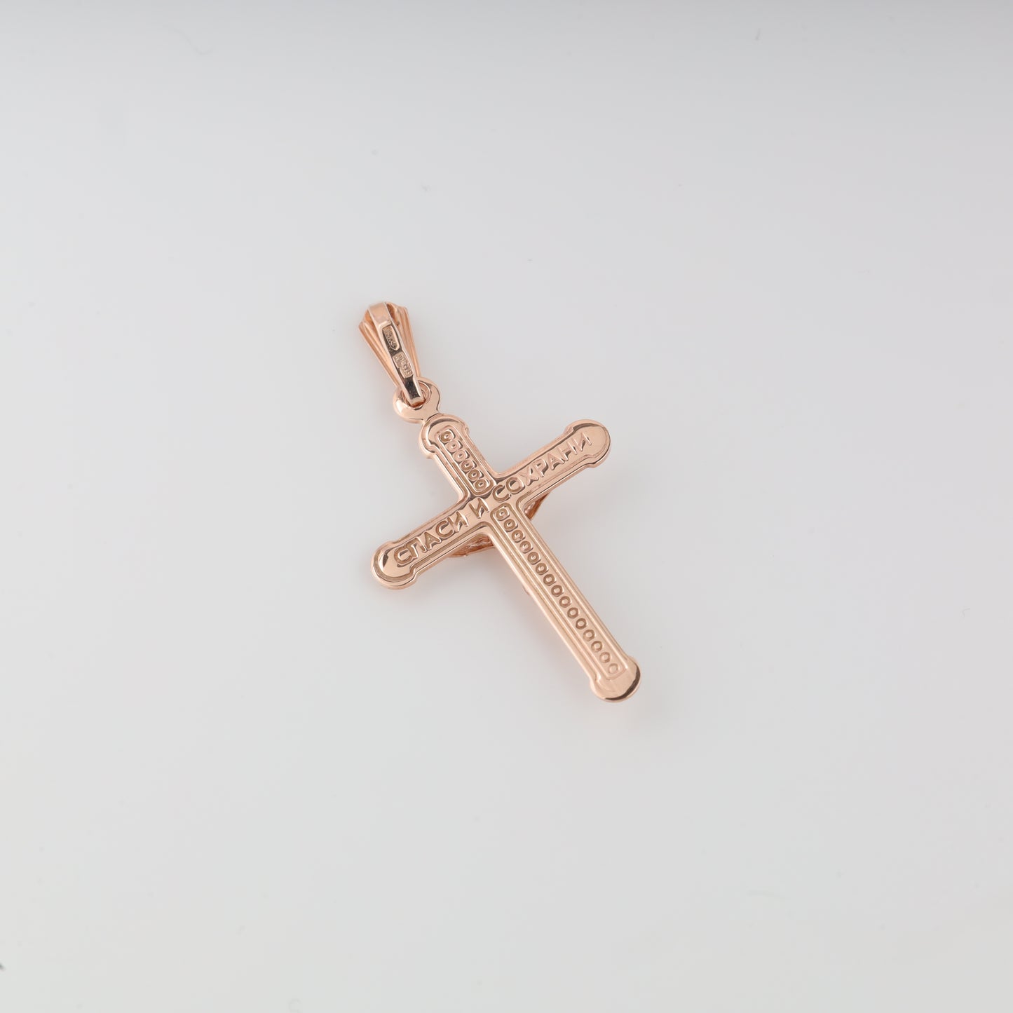 The reverse side of a 14K (585) Rose Gold cross pendant with the traditional protective inscription 'СПАСИ И СОХРАНИ' engraved in elegant Cyrillic script
