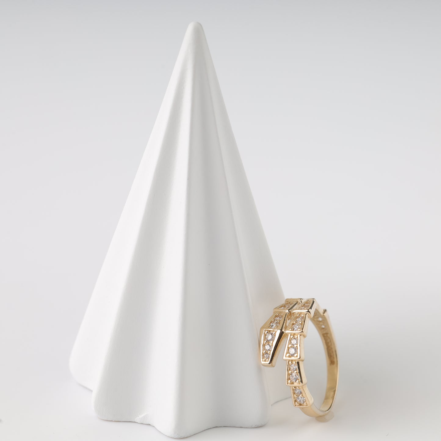 An elegant 14K Rose Gold ring shaped like a coiled snake with shimmering inserts.