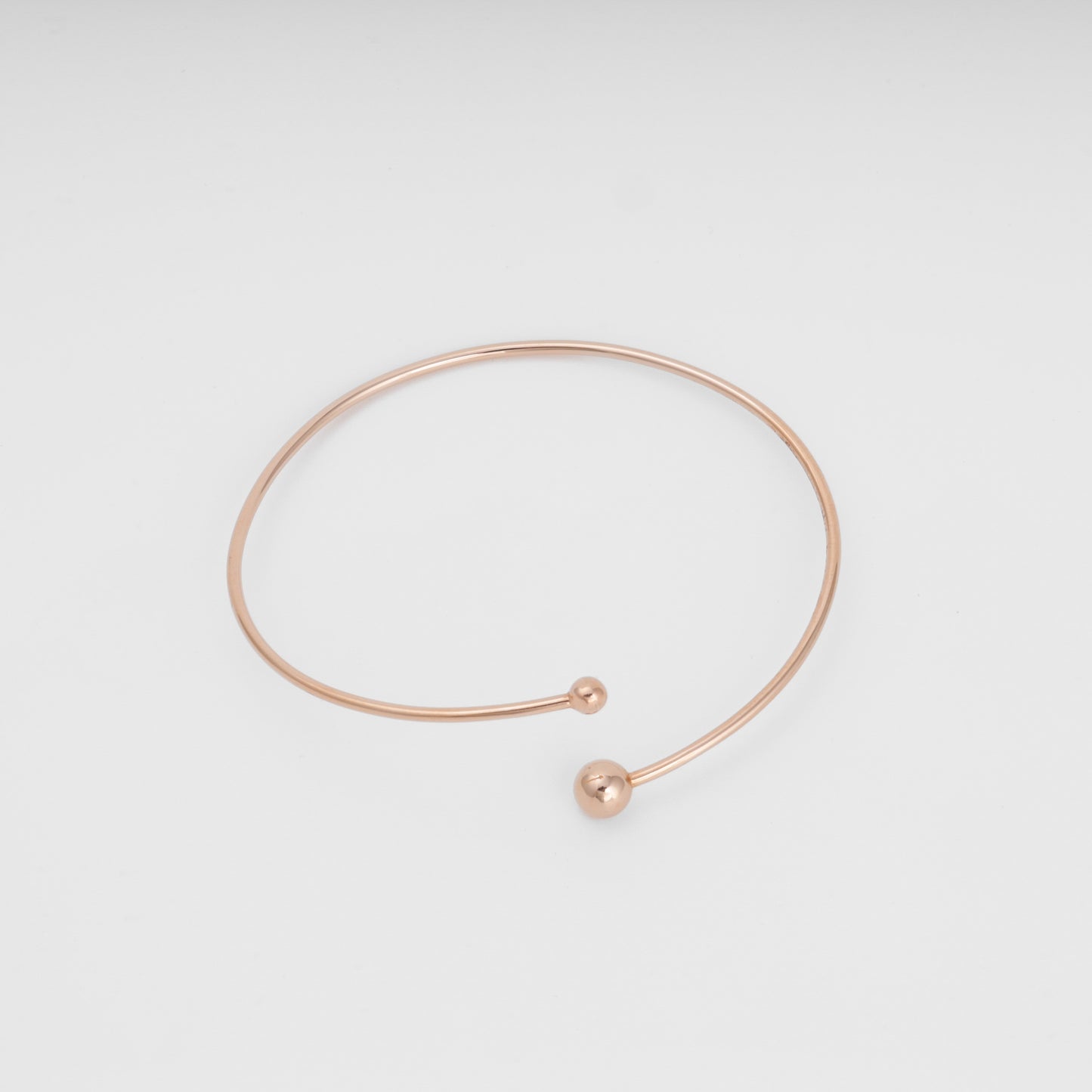 Minimalist 14k gold open bangle bracelet with two ball ends on white background, Ukrainian Jewelry, dainty gold bracelet gift.