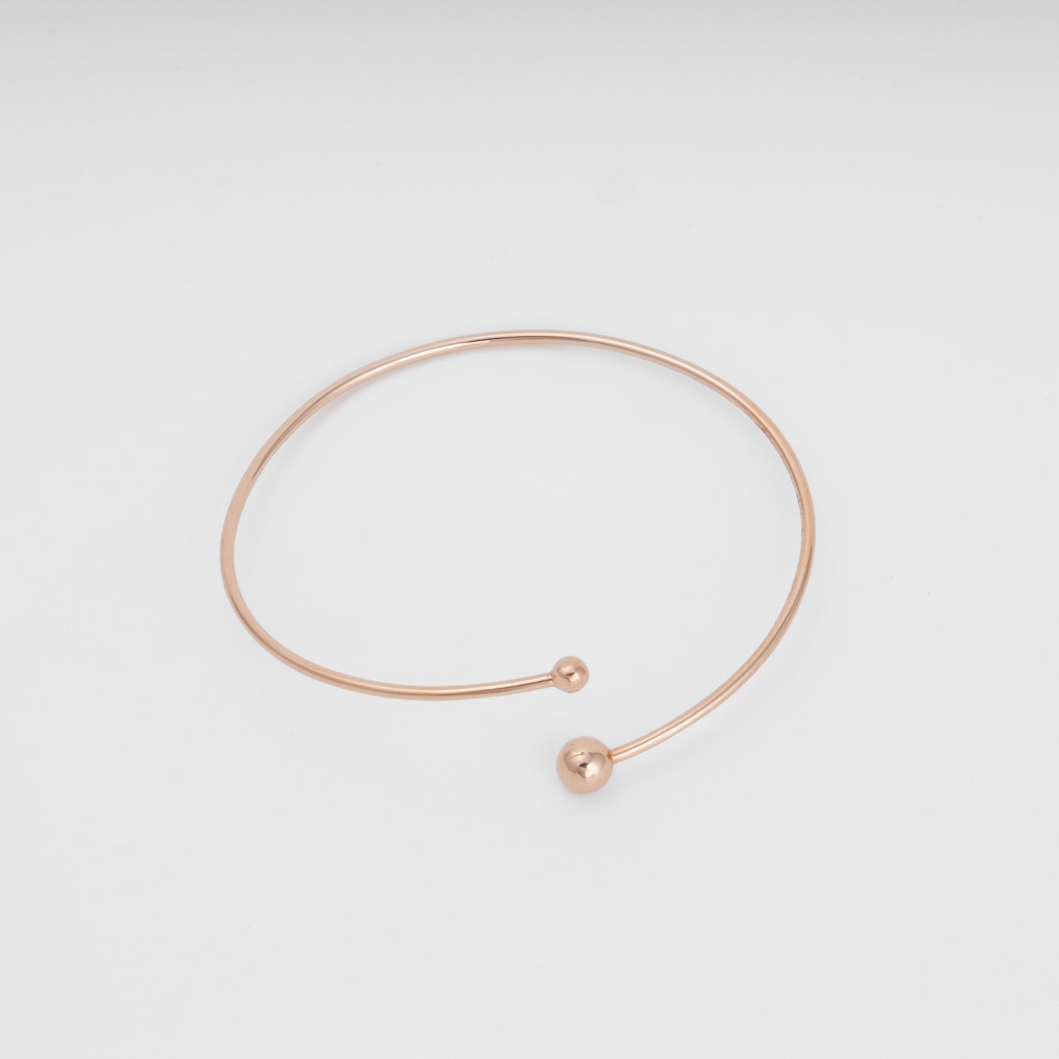 Minimalist 14k gold open bangle bracelet with two ball ends on white background, Ukrainian Jewelry, dainty gold bracelet gift.