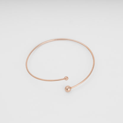 Minimalist 14k gold open bangle bracelet with two ball ends on white background, Ukrainian Jewelry, dainty gold bracelet gift.
