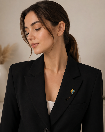 Blue and yellow wheat safety pin brooch styled on a lapel
