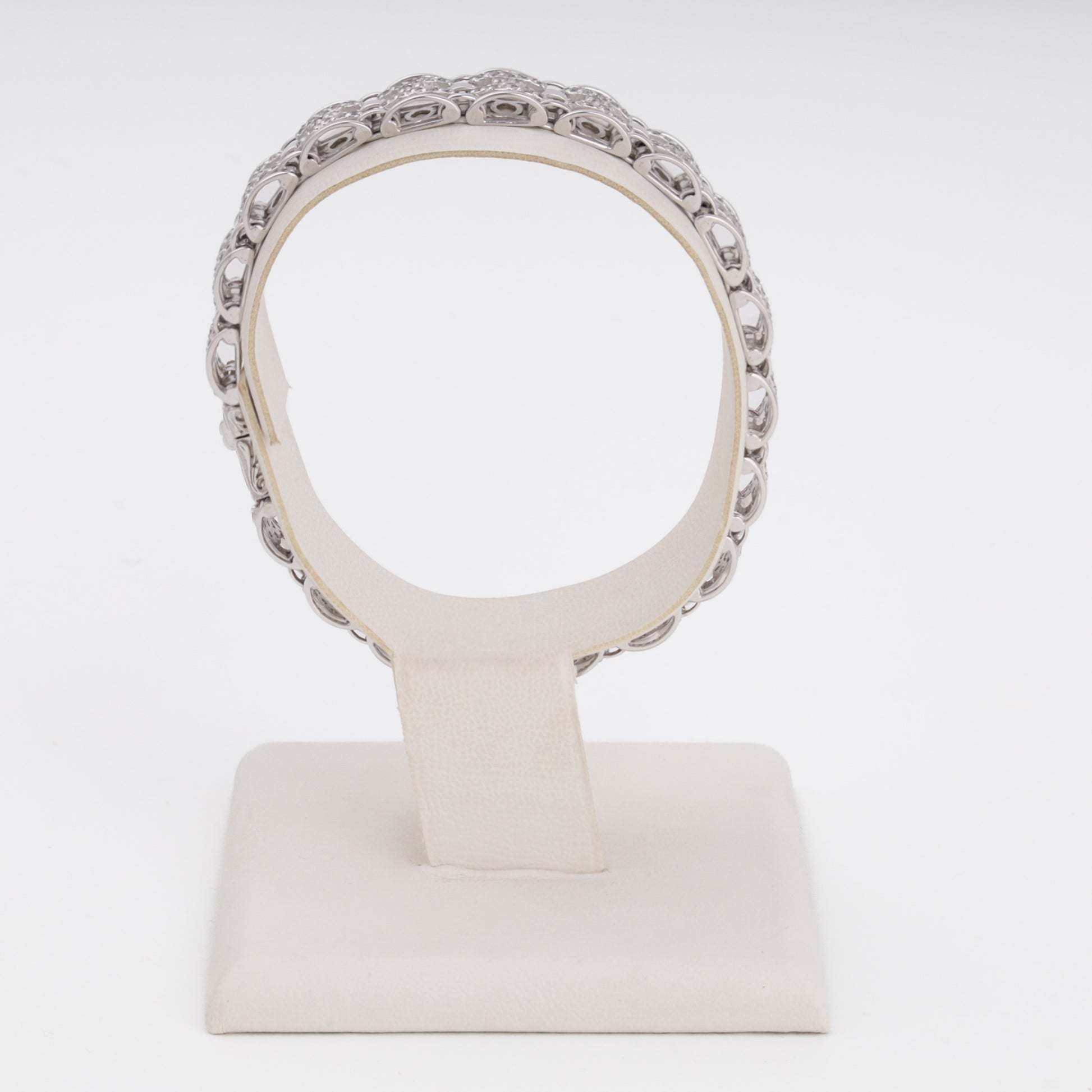 Abstract sculptural bracelet in white gold displayed on stand — Kabluchka