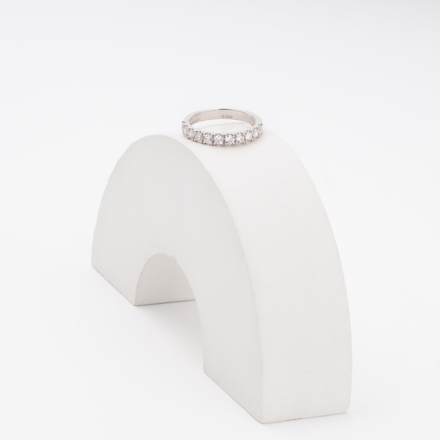 Diamond white gold ring displayed on arch prop showing brilliant-cut stones - Kabluchka
