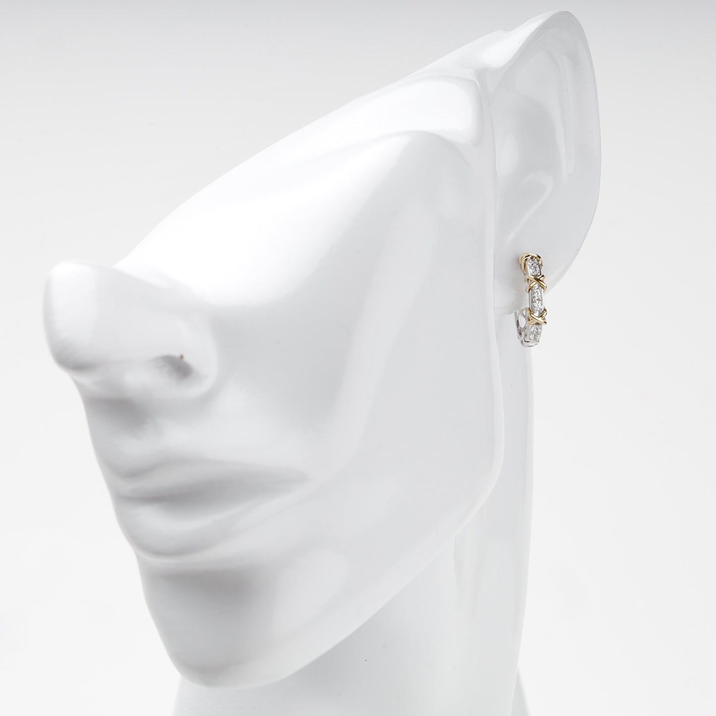 Two-tone gold huggie earring shown on ear