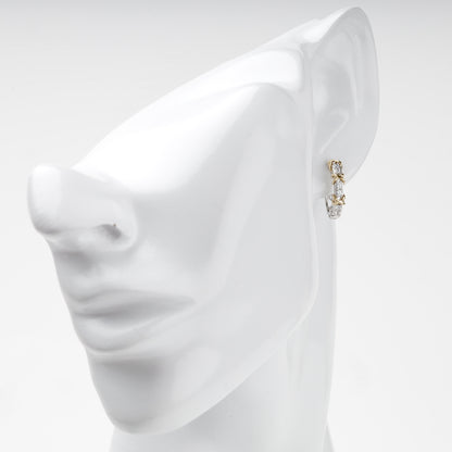 Two-tone gold huggie earring shown on ear