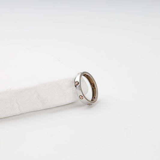 White and rose gold screw motif ring, angled side view