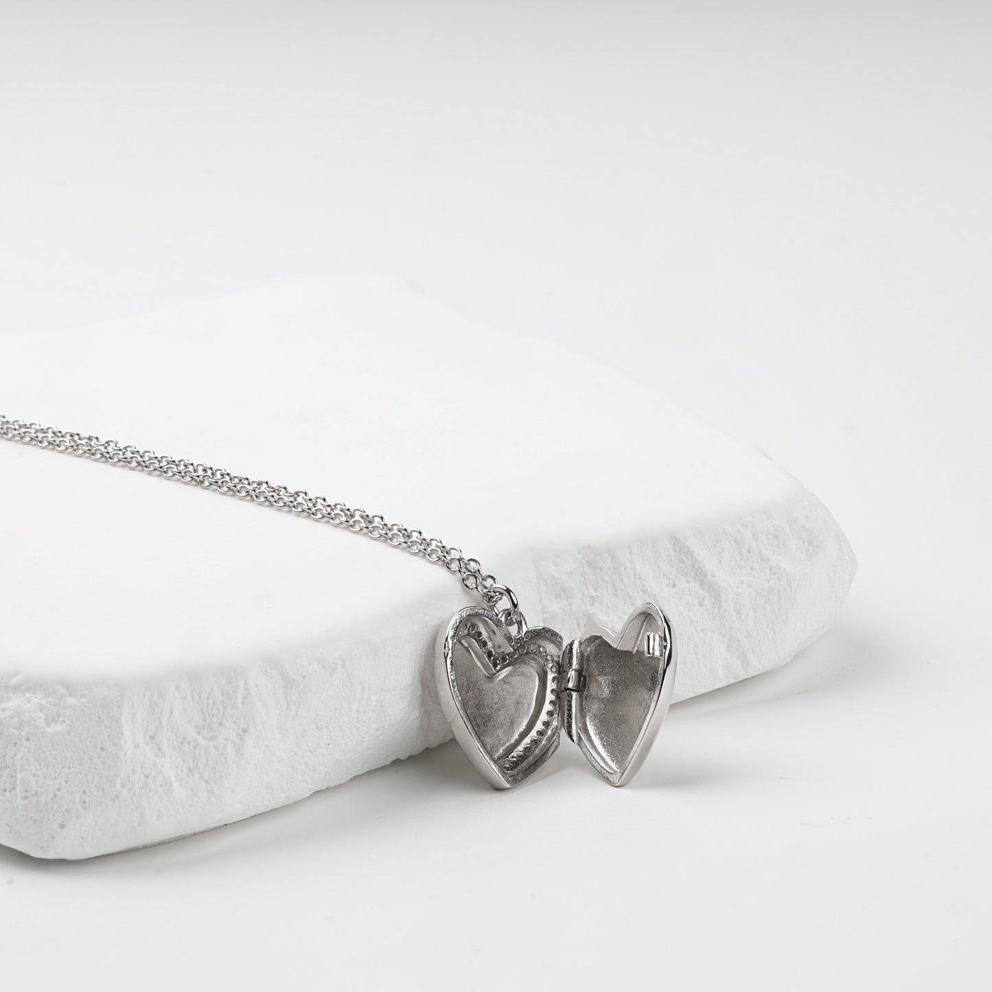 Open heart locket showing two interior photo recesses