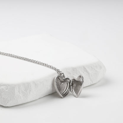 Open heart locket showing two interior photo recesses