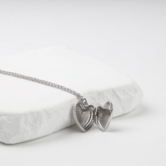 Open heart locket showing two interior photo recesses
