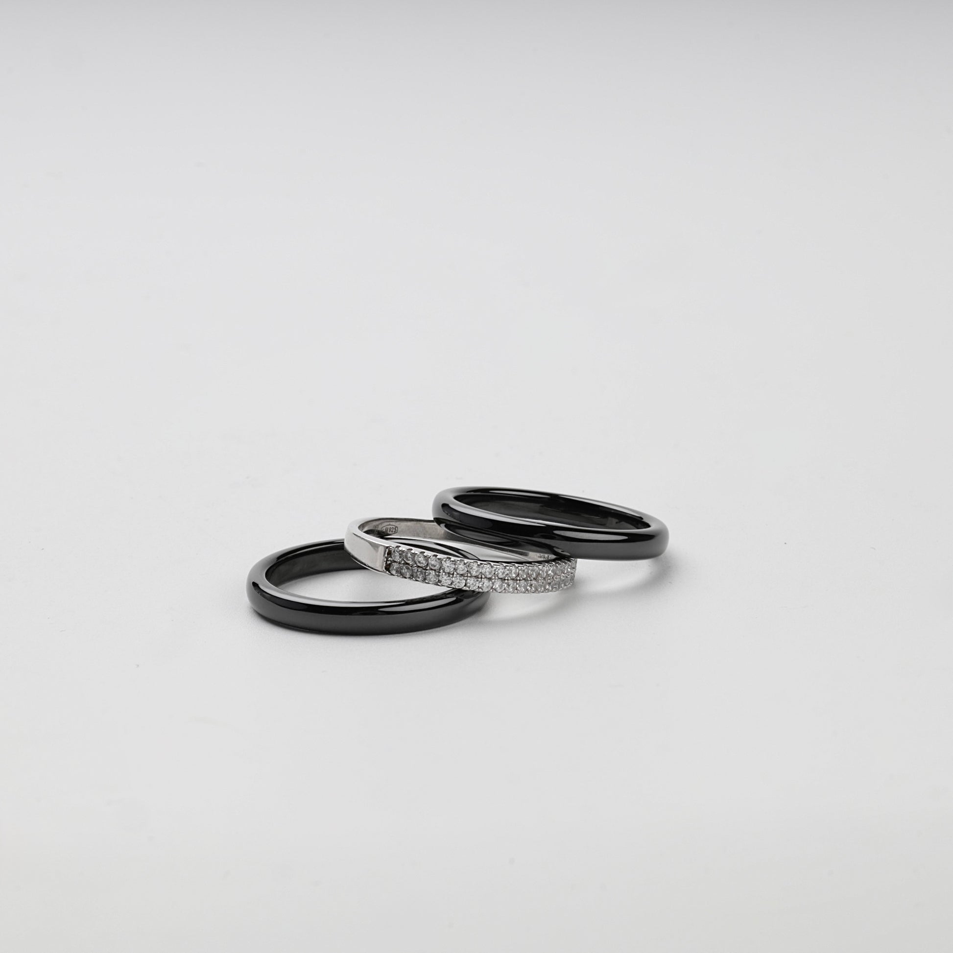 Separate black ceramic and Silver 925 cubic zirconia rings arranged together