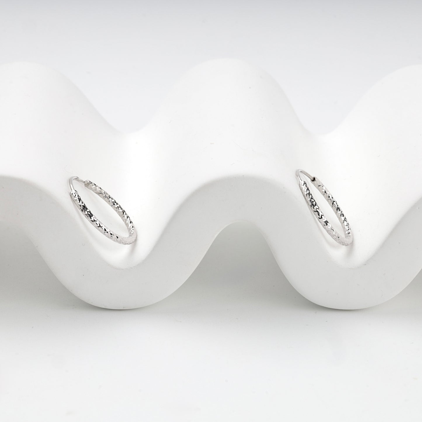 Silver 925 textured hoop earrings, angled view