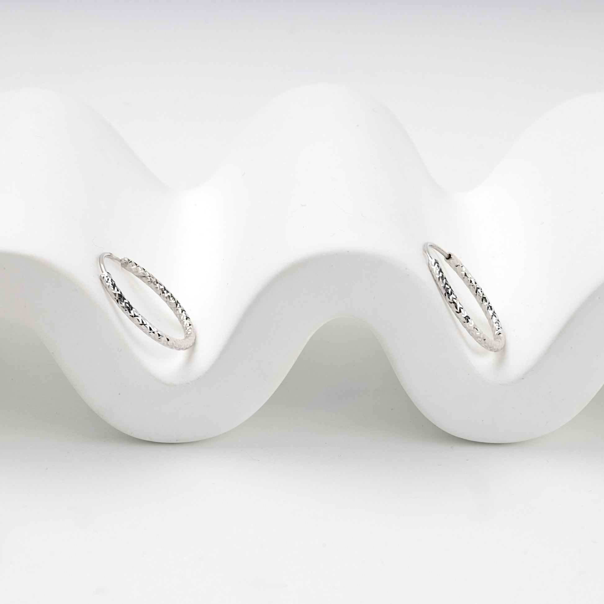 Silver 925 textured hoop earrings, angled view