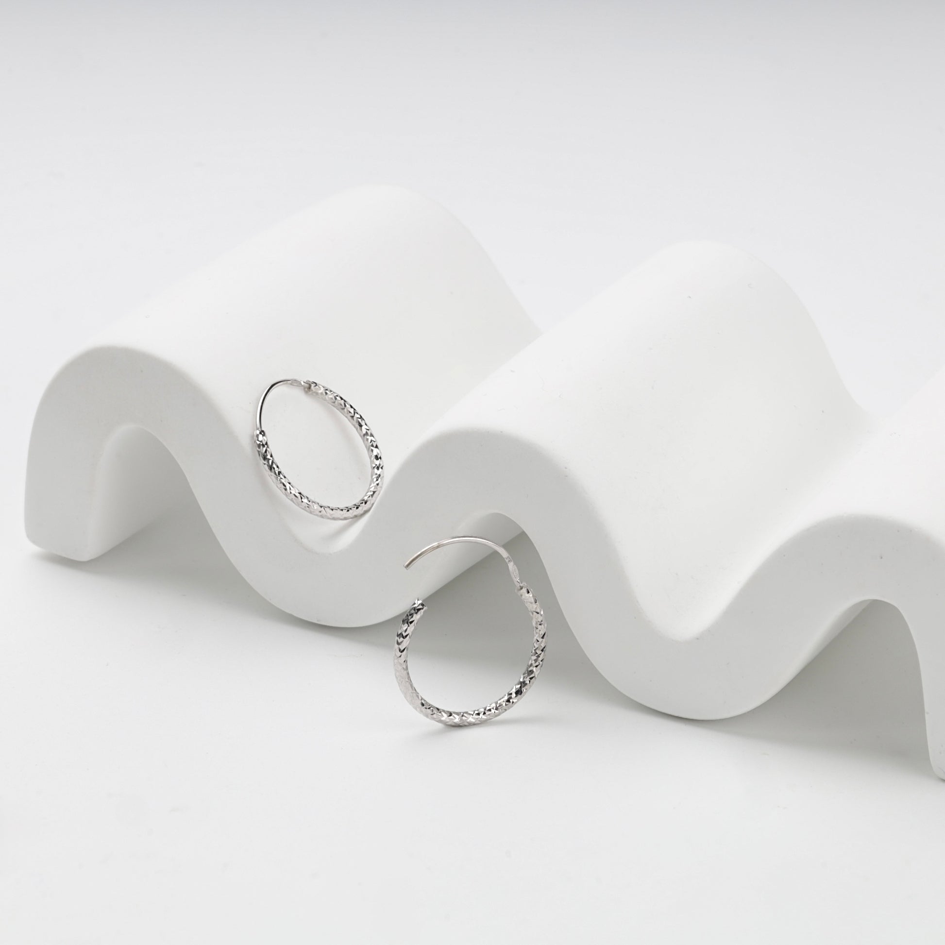 Integrated hinged wire closure on silver hoop earrings