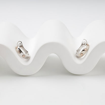 Two-tone 14K gold hoop earrings with rose-gold screw motifs, front view