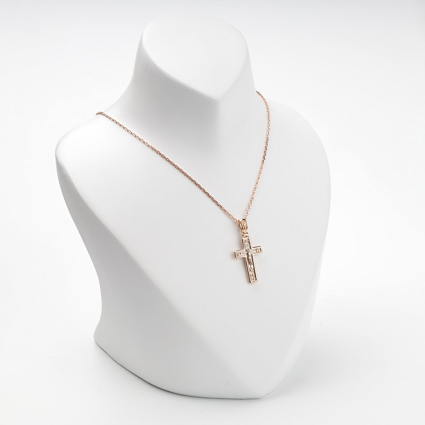 Two-tone gold Crucifixion cross pendant on display