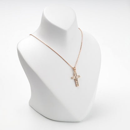 Two-tone gold Crucifixion cross pendant on display