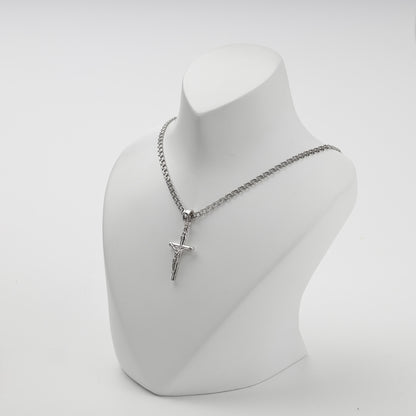 Polished silver crucifix pendant shown at an angle