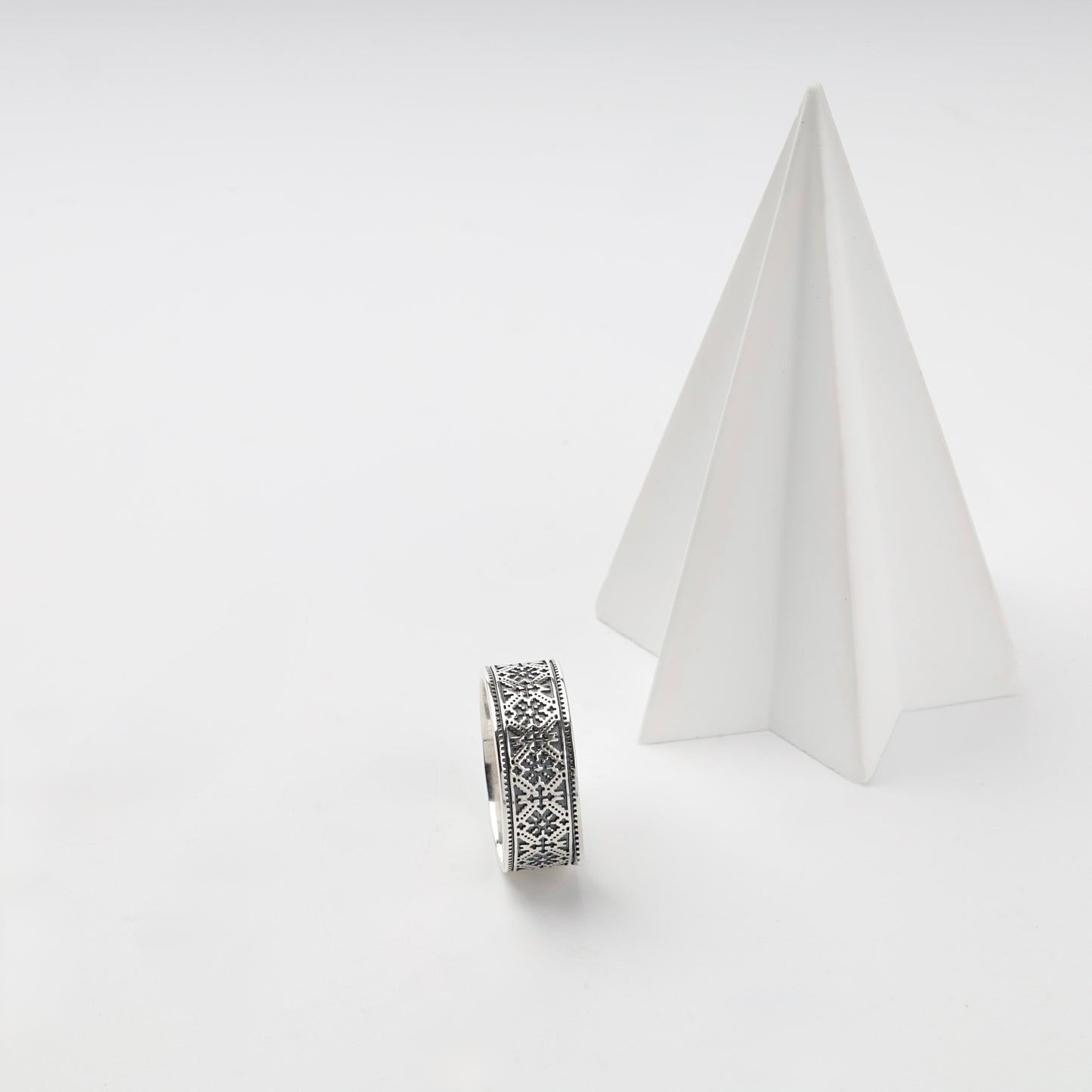 Darkened Ukrainian geometric pattern on a silver band ring