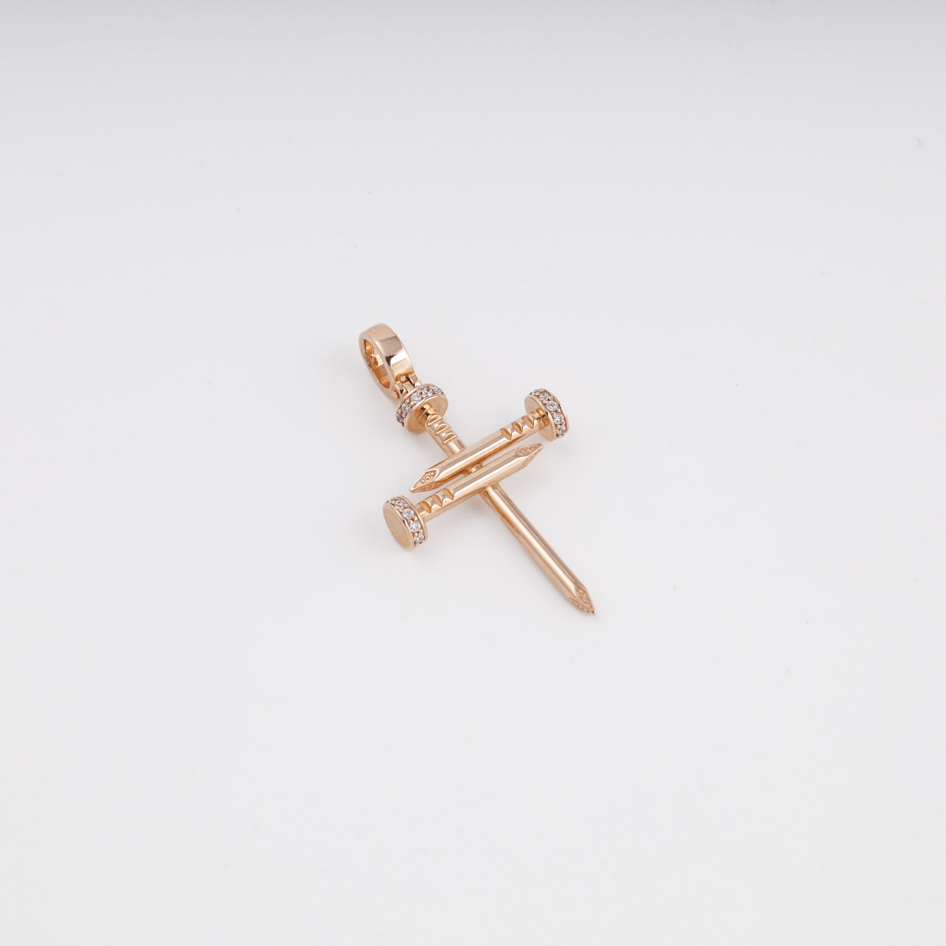 Rose gold nail cross pendant close-up showing zirconia detail