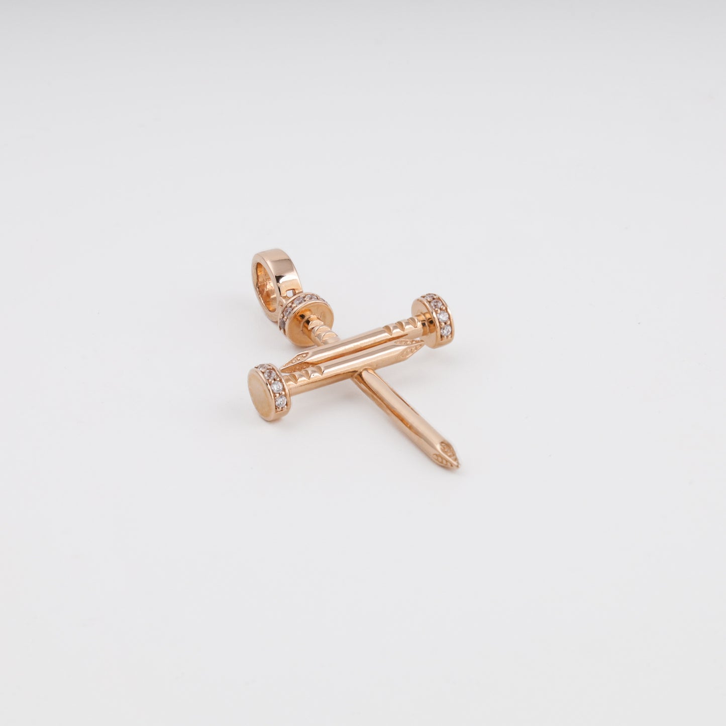 Gold nail cross pendant detail with cubic zirconia nail heads