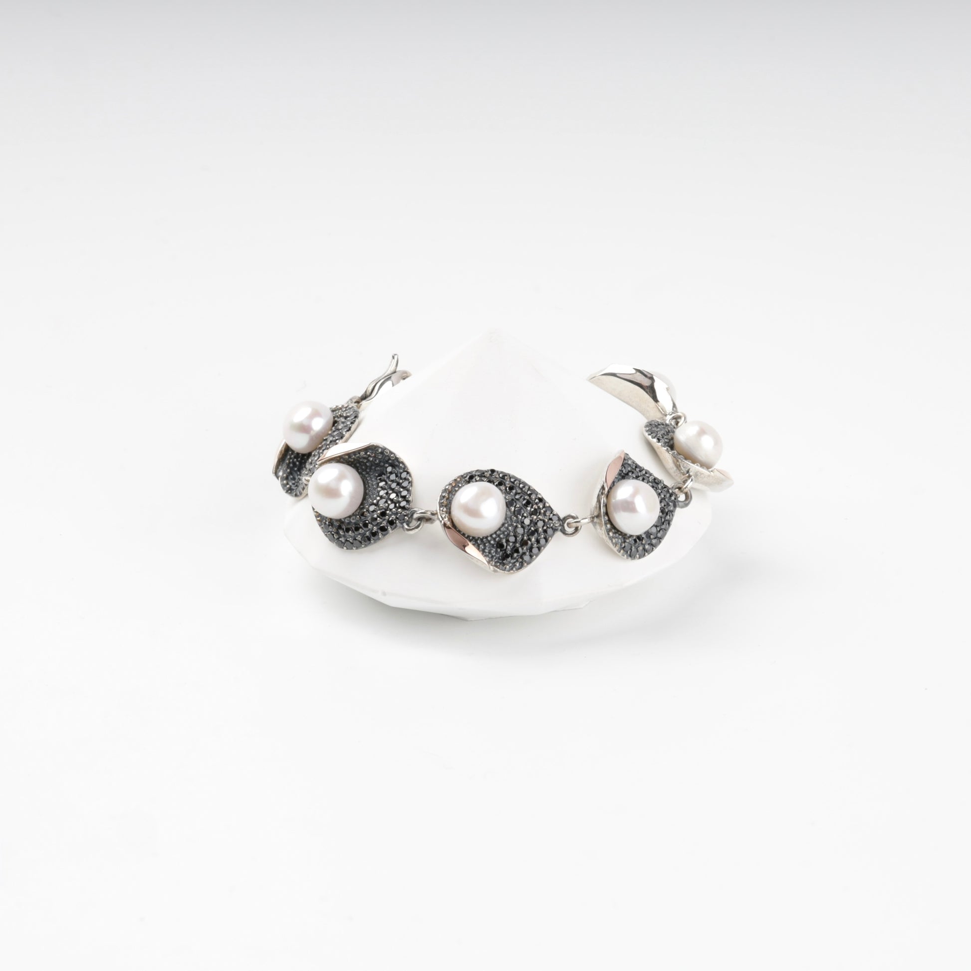 Silver and gold pearl link bracelet with dark cubic zirconia, front view