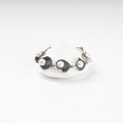 Silver and gold pearl link bracelet with dark cubic zirconia, front view