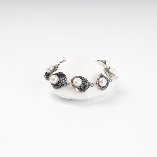 Silver and gold pearl link bracelet with dark cubic zirconia, front view