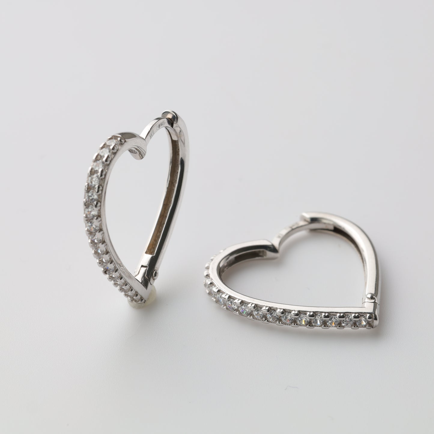 Silver heart-shaped huggie earrings close-up - Kabluchka