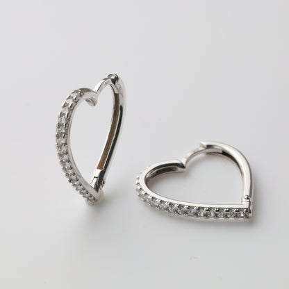 Silver heart-shaped huggie earrings close-up - Kabluchka