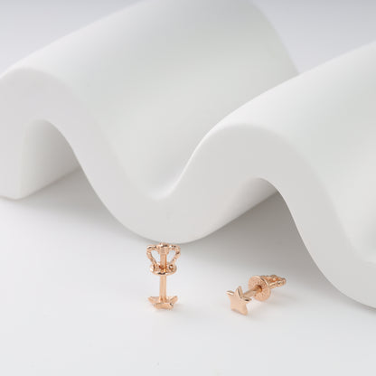 Rose gold earrings on a white fabric background