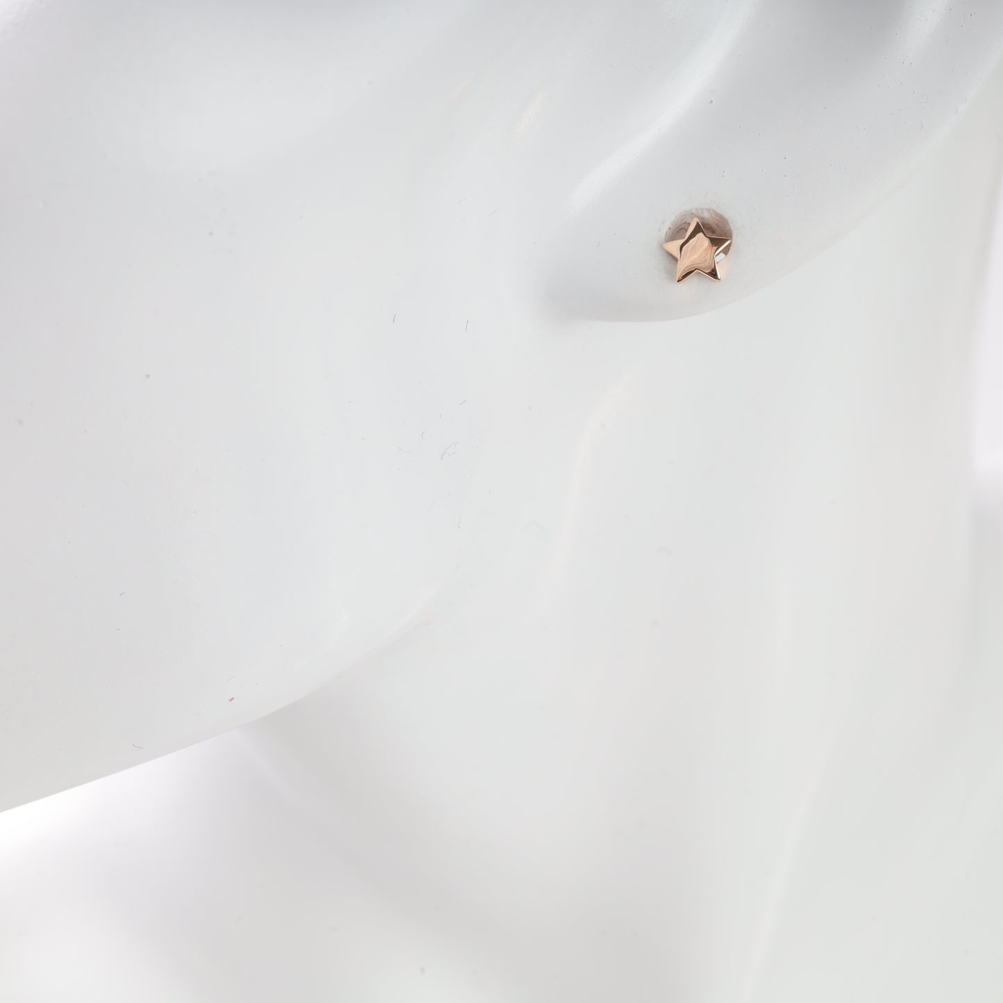 Close-up of a star-shaped earring on a white background