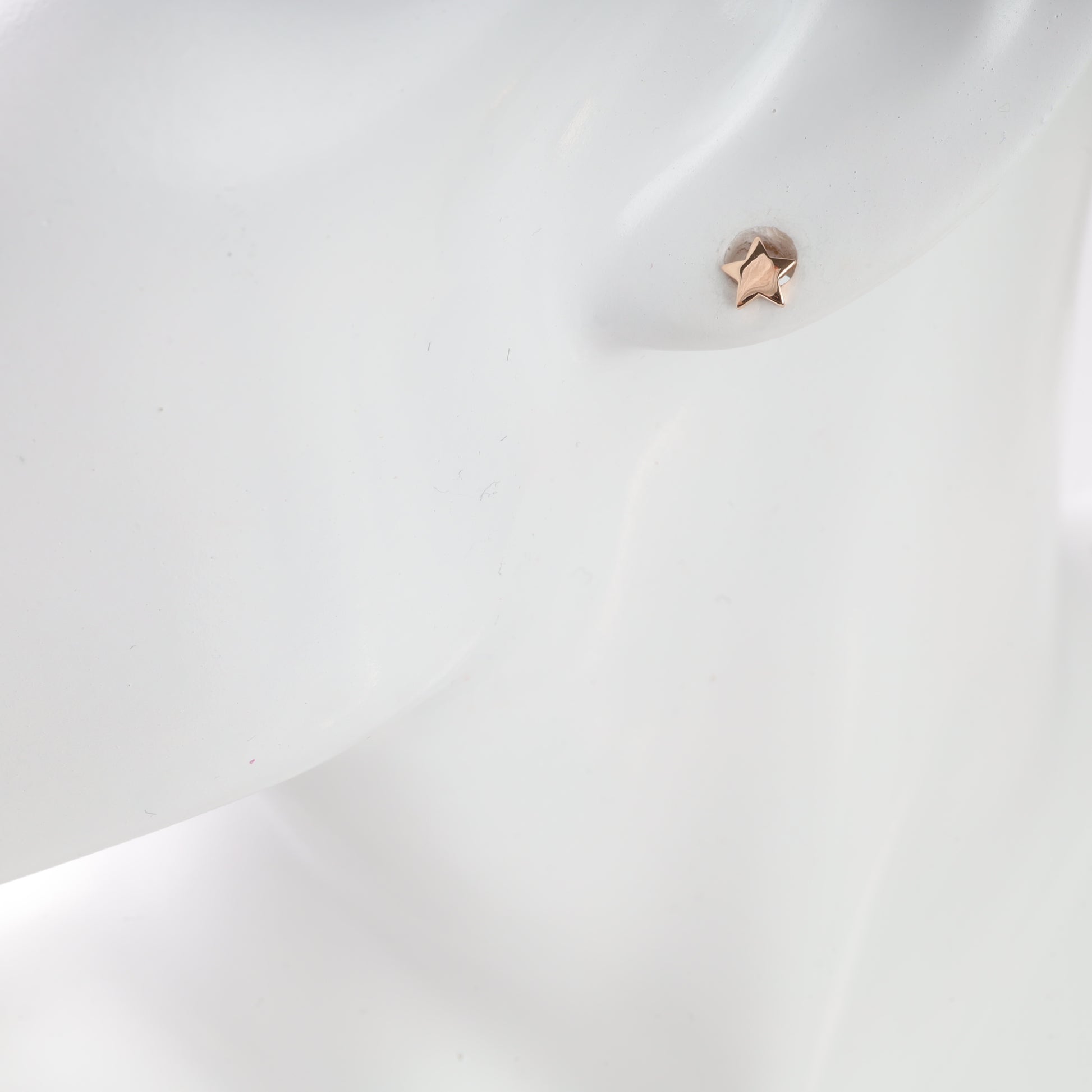 Close-up of a star-shaped earring on a white background