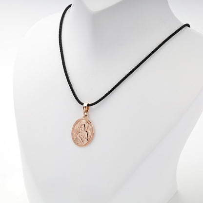 Rose gold religious icon pendant worn on a black styling cord