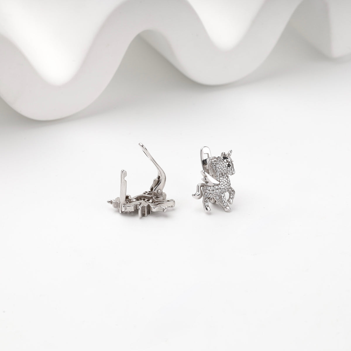 Winged unicorn earrings with English-lock backs open