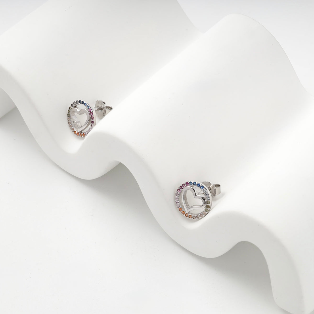 Silver 925 rainbow cubic zirconia heart earrings on a white display