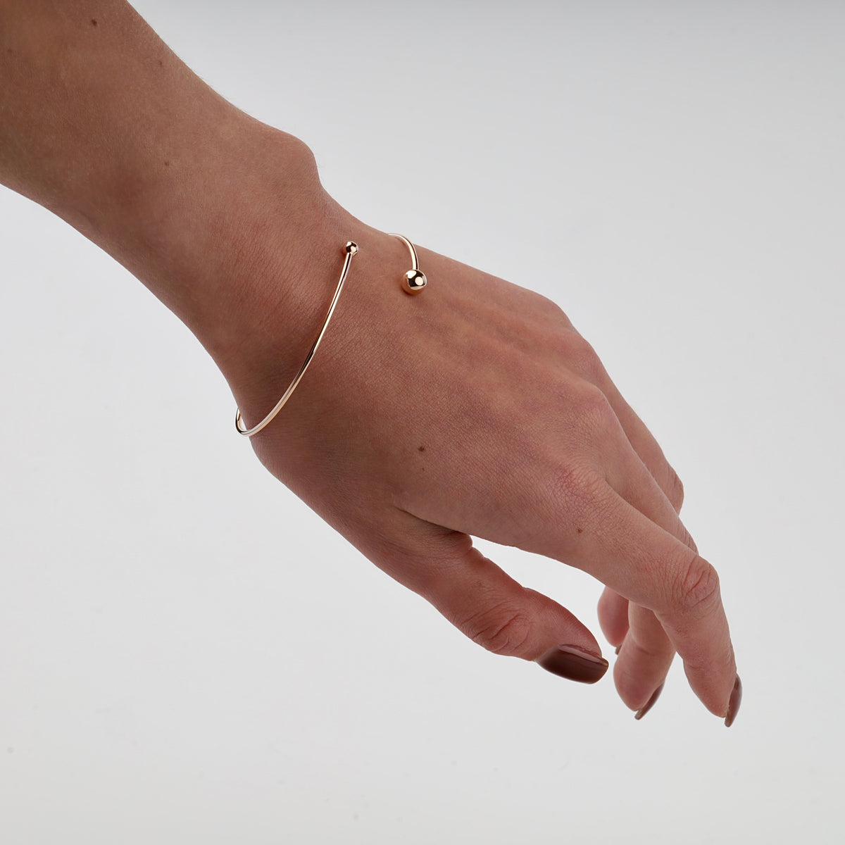 Polished rose gold open cuff bracelet with ball ends