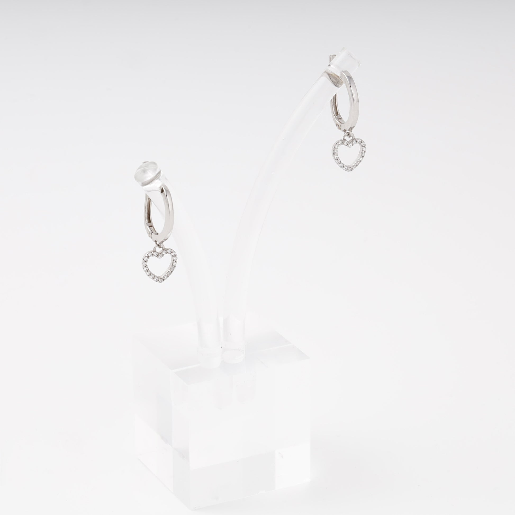 Silver drop earrings with open heart charm and cubic zirconia on display stand, side view — Kabluchka