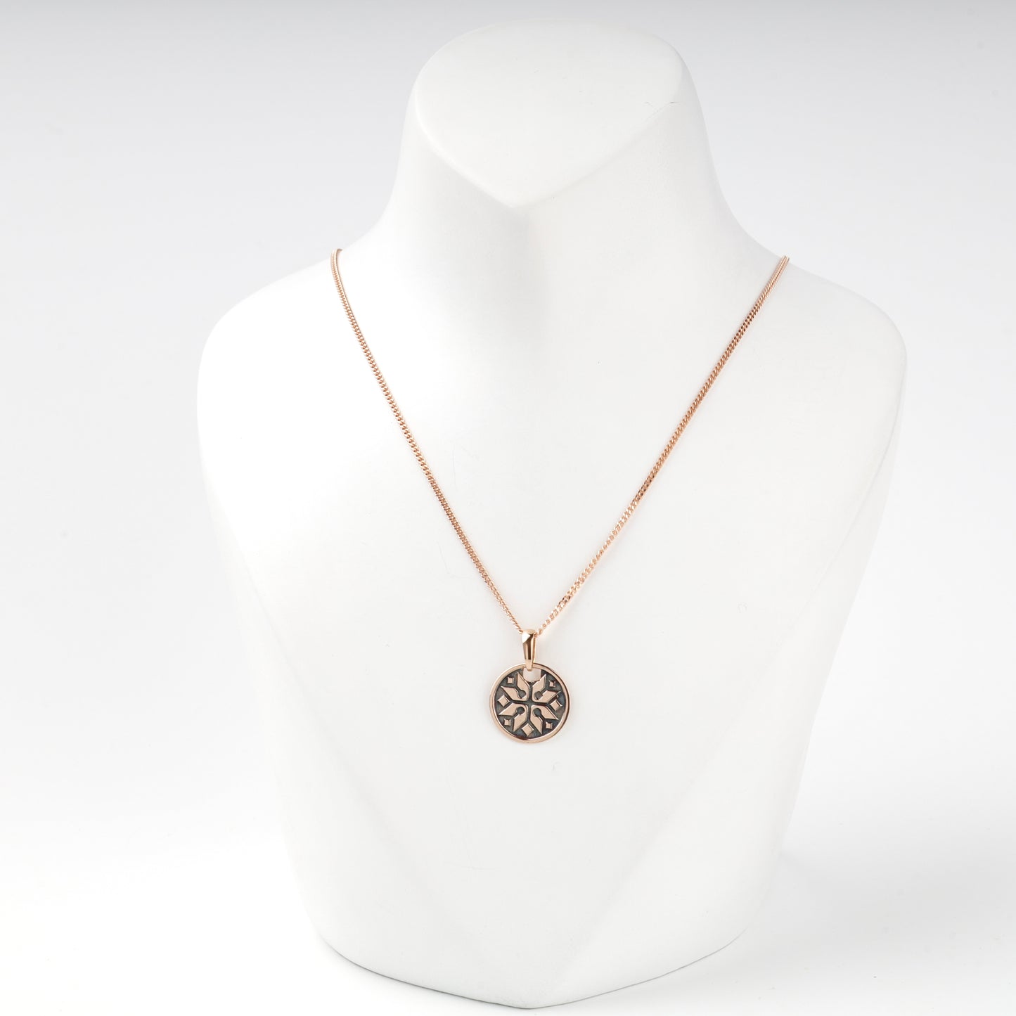 Geometric Ukrainian ornament on a polished rose gold pendant