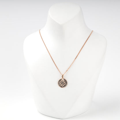 Geometric Ukrainian ornament on a polished rose gold pendant