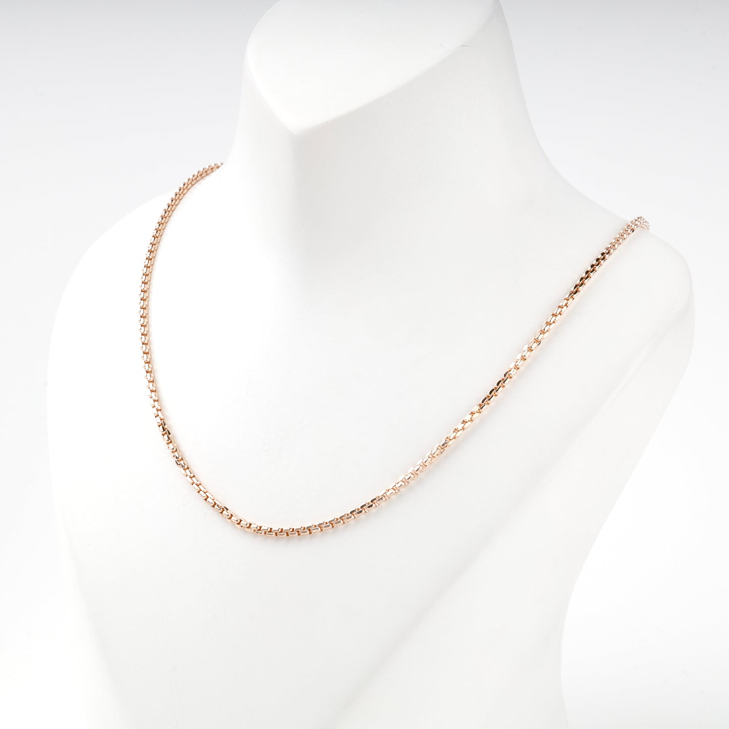Compact squared links on a rose gold box chain, close view