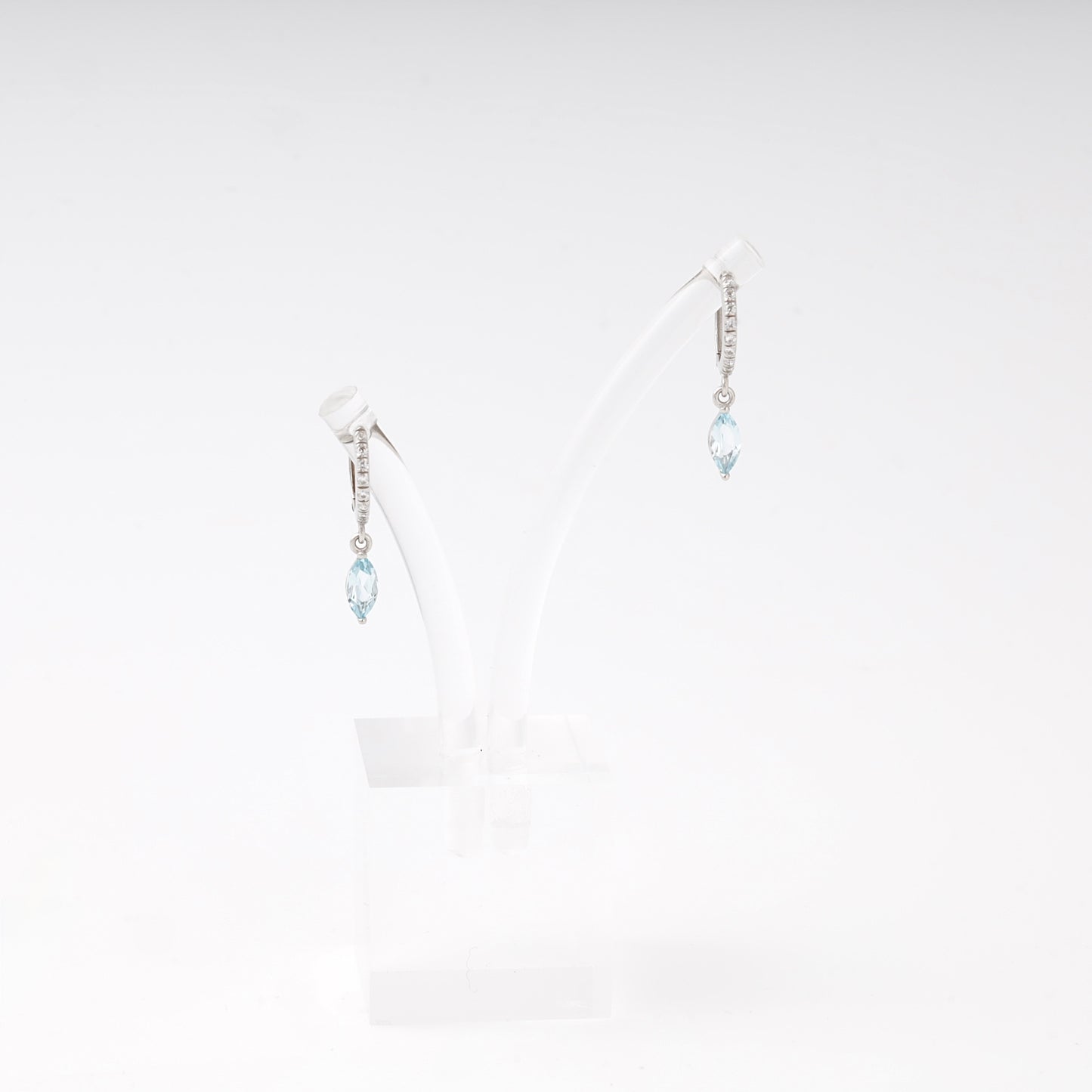Silver 925 huggie earrings with blue topaz drop on display — Kabluchka