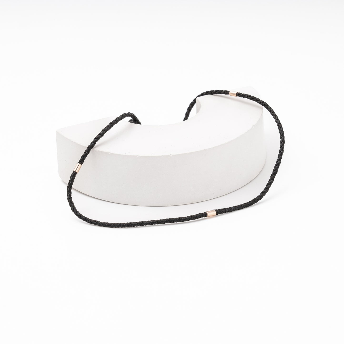 Braided black necklace cord with gold fittings close-up — Kabluchka