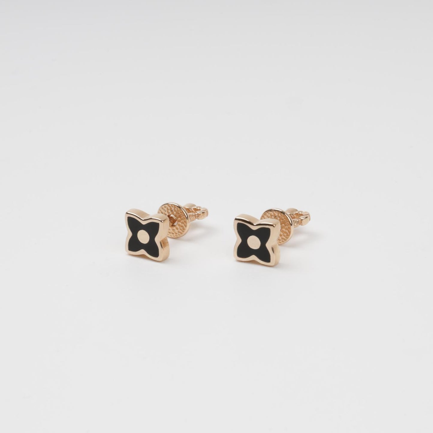 Symmetric view of minimalist 14K Rose Gold stud earrings with pointed clover petals and smooth black enamel inlay.