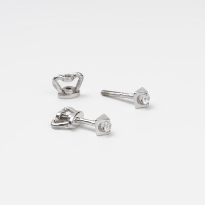 14K (585) White Gold geometric stud earrings and their corresponding screw-on locks displayed on a textured white surface, highlighting the brilliant metallic finish.