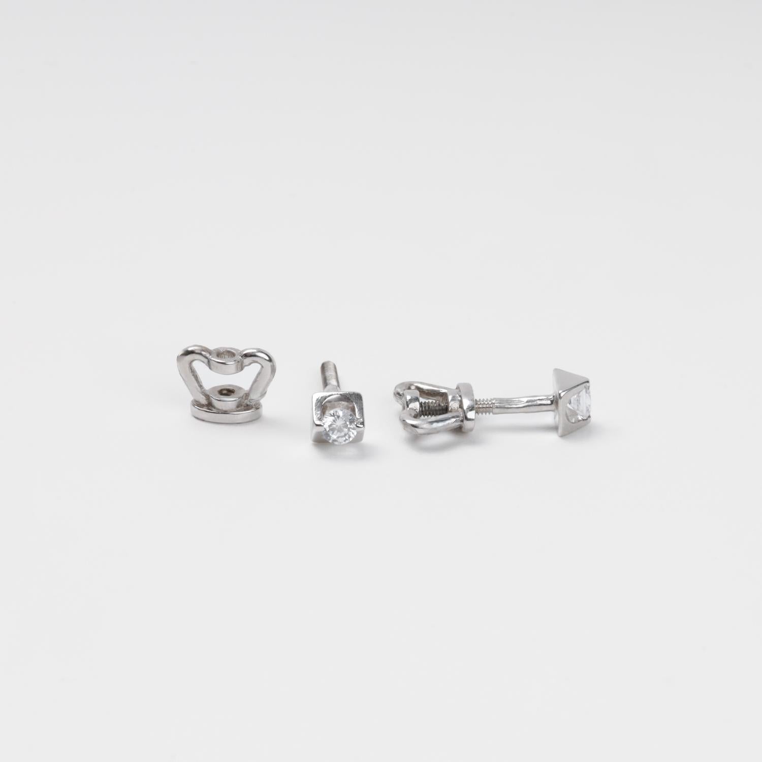 14K (585) White Gold geometric stud earrings and their corresponding screw-on locks displayed on a textured white surface, highlighting the brilliant metallic finish.