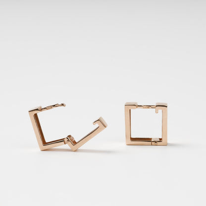 Detailed view of the hinged snap-lock mechanism and 585 hallmark on 14K rose gold square earrings.