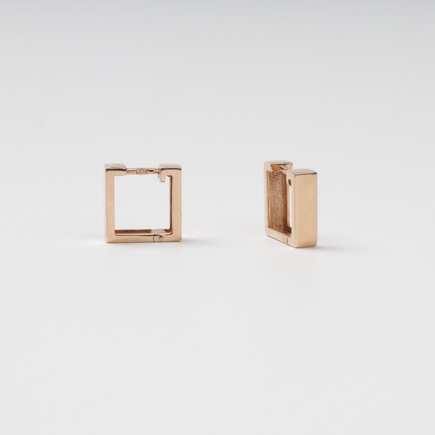 Professional jewelry photography showing the thickness and clean profile of modern 14K (585) Rose Gold square huggie hoops.